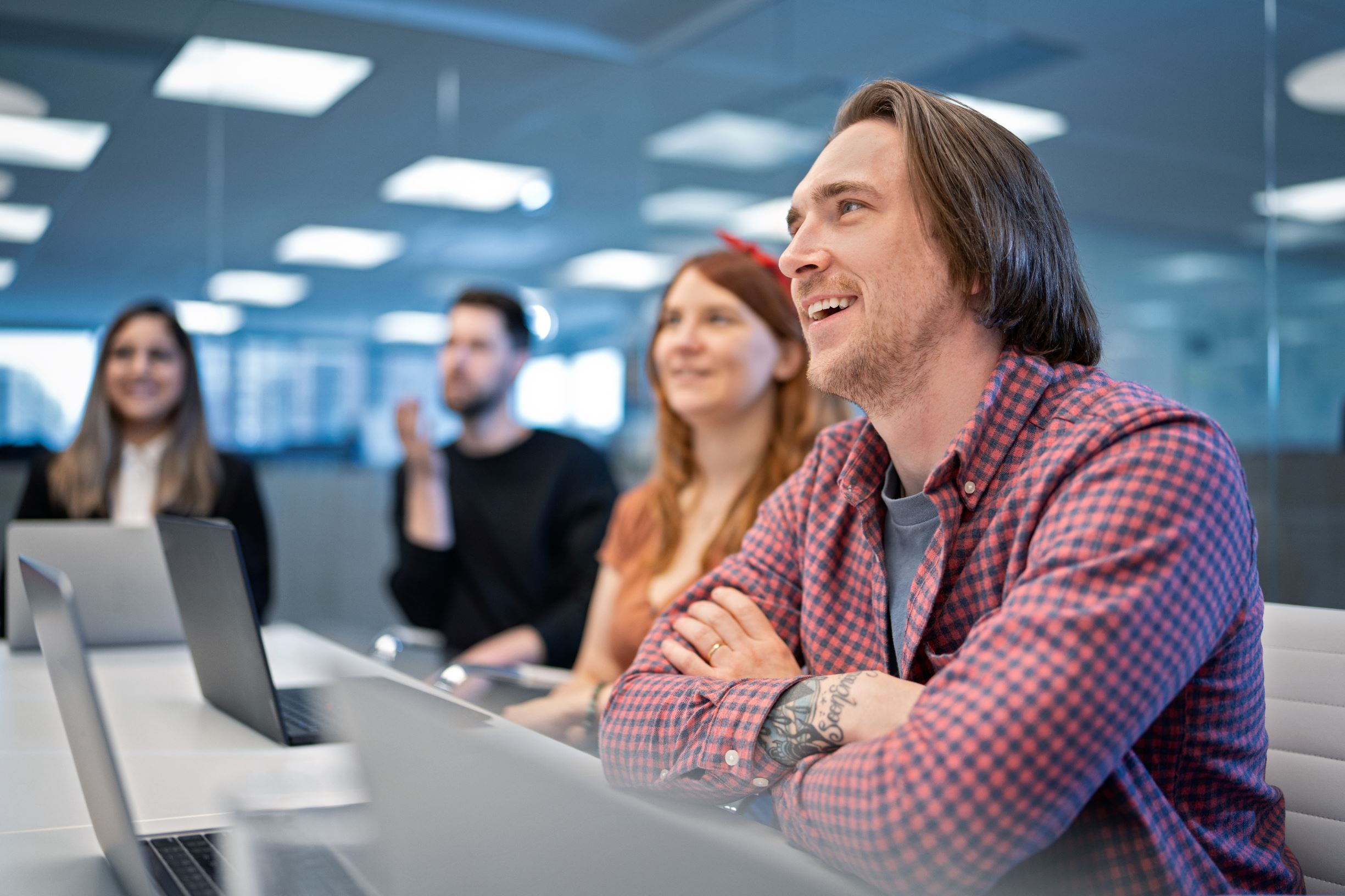 Helcim team in meeting gathered around a table smiling and ideating.