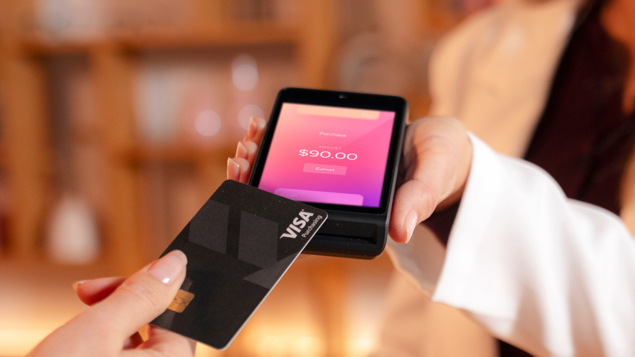merchant holding credit card reader for payment