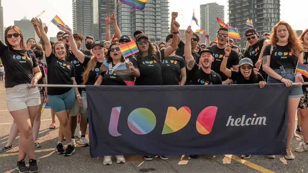 Helcim team members at 2022 Pride Parade posing for a photo with Helcim "love" Banner