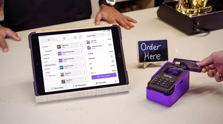 retailer in-person checkout with touch screen and card reader on the sales table