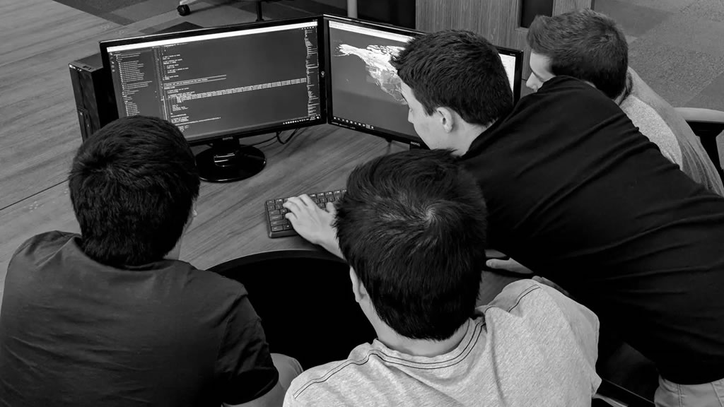 helcim devs around a computer working on code together