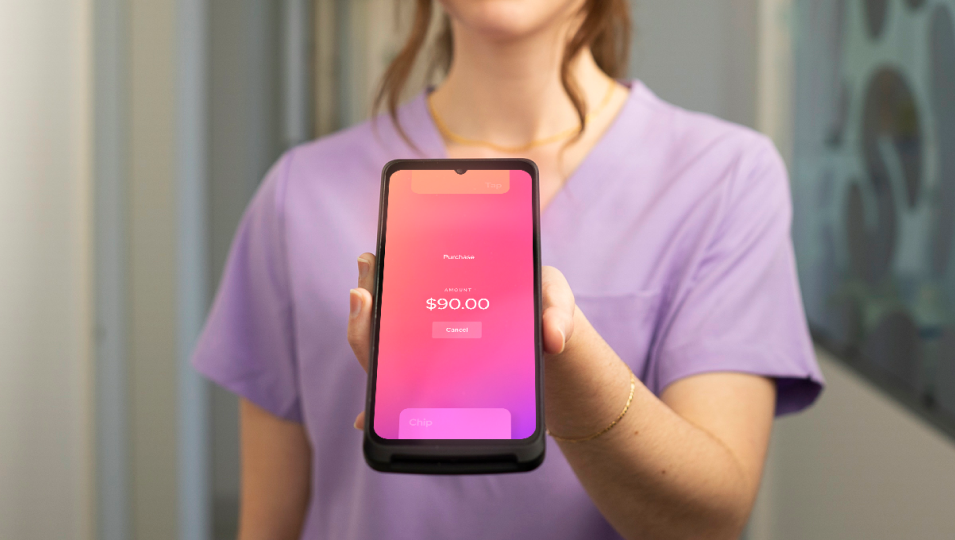 The Helcim Smart Terminal placed on a table next to a laptop