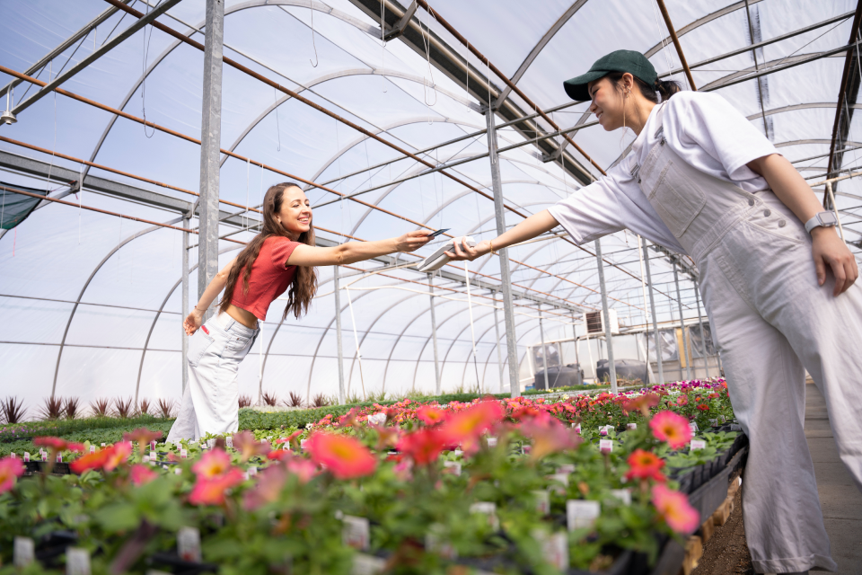 Two people in a garden house making a contactless payment